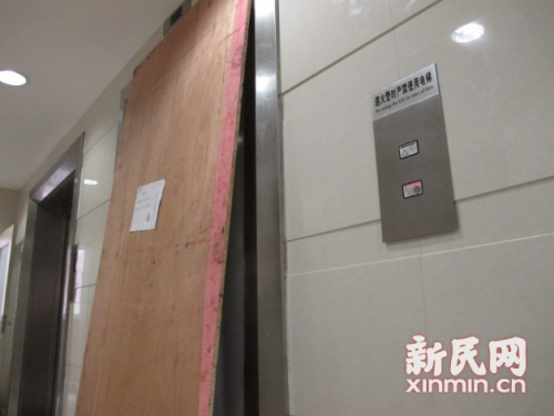 图说:电梯门被一块木板挡住.新民网记者 沈文林 现场回传