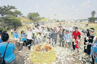 义山公祭活动上,居民焚烧大批金银纸,也不断往头上抛洒一把一把的纸钱