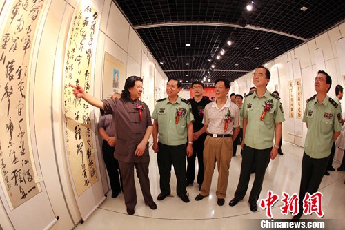 图为中国书法家协会展览部主任吴震启(左一)向公安部消防局局长陈伟明