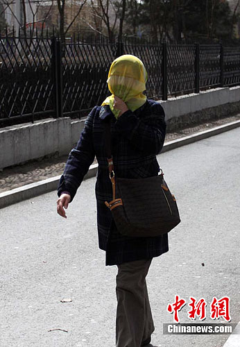 在长春市,路上行人都以纱巾,口罩等物品掩面以防风中的沙尘进入眼睛