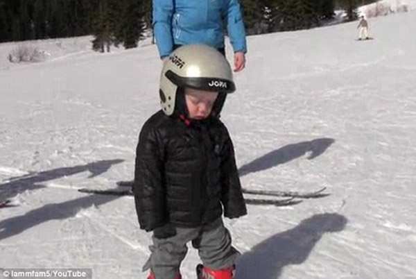 可爱小男孩学滑雪打盹摔倒